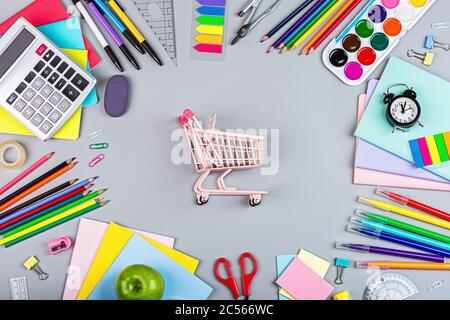 Torna a scuola con carrello della spesa. Collezione di forniture scolastiche in stile luminoso e piatto. Concetto educativo. Spazio di copia, mockup, overhead Foto Stock