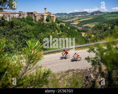 Due ciclisti in giro in Appennino su una strada solitaria nei pressi di Talamello, provincia di Rimini, in Emilia Romagna. Foto Stock