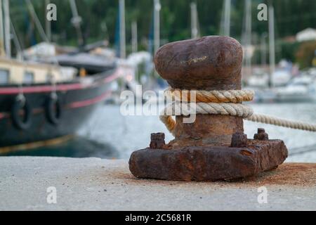 Corde di una nave avvolta intorno ad un bollard di ormeggio sopra il molo Foto Stock