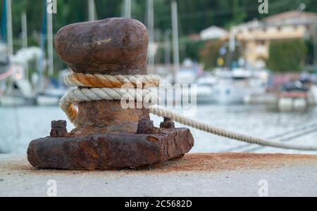 Corde di una nave avvolta intorno ad un bollard di ormeggio sopra il molo Foto Stock