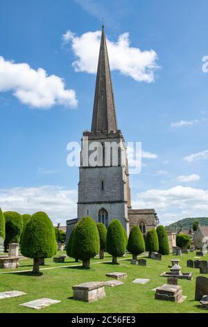 Chiesa di St Marys e gli alberi di tasso alla luce del sole. Painswick, Gloucestershire, Inghilterra Foto Stock