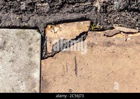 Spaccato dal bordo delle vecchie lastre di pavimentazione da vicino. Foto Stock