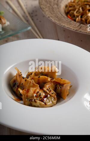 Gnocchi decorati con salsa e semi di chia e serviti in una piastra bianca Foto Stock