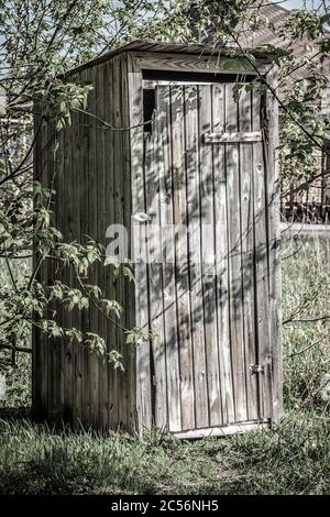 wc rustico fatto di tavole in primo piano della strada. Foto Stock