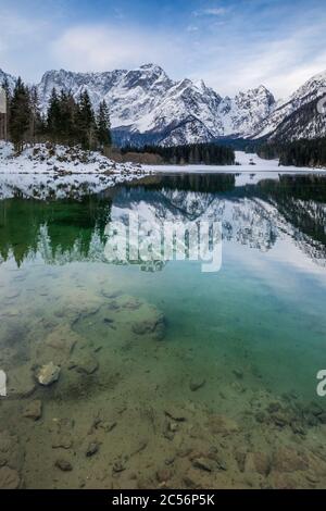 Il lago superiore di Fusine con il monte Mangart sullo sfondo in inverno. Parco Naturale dei Laghi di Fusine, Fusine di Valromana, Tarvisio, provincia di Udine, ven Foto Stock