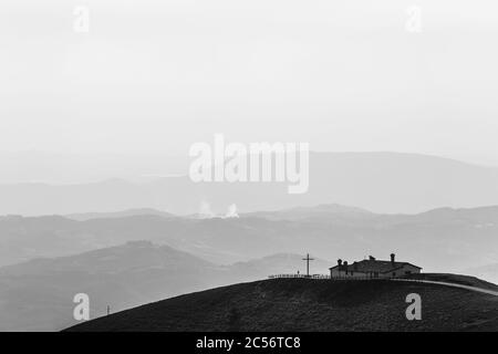 Veduta dell'eremo Serrasanta Umbria, Italia in cima ad una montagna, con diversi altri strati di montagna sullo sfondo Foto Stock