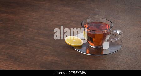 Tazza di tè su tavolo di legno. Tazza in vetro con teabag. Tè nero, marrone caldo. rendering 3d. Foto Stock