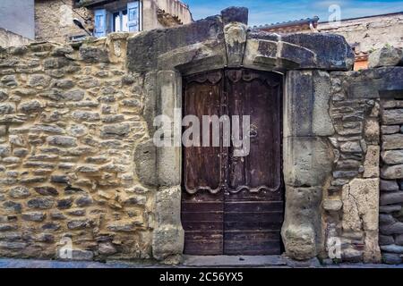 Vecchia porta rotonda in legno a Siran Foto Stock