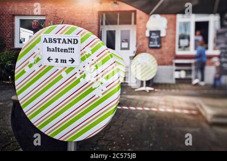 Immagine simbolica di distanza sociale, segno con avviso di fronte al gelateria, mantenere la distanza, 2 metri Foto Stock