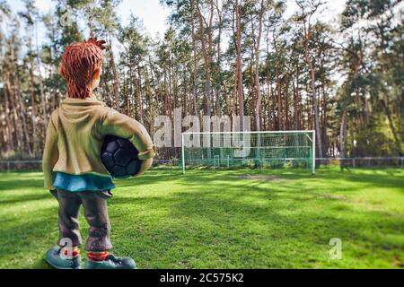 Simbolico immagine blocco, diorama, miniatura, calcio gol di fronte alla foresta, ragazzo solitario con palla Foto Stock