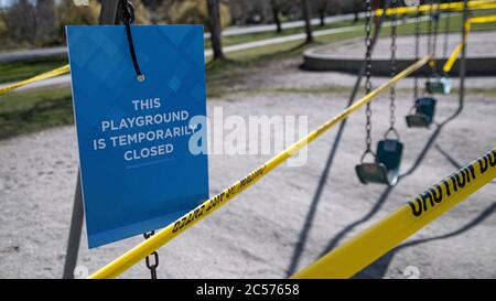 Parco giochi chiuso cartello e nastro durante la pandemia COVID-19 Foto Stock