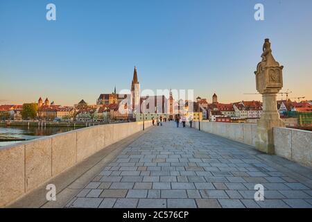 Ponte in pietra verso la cattedrale di Ratisbona nella città vecchia alla luce della sera, Ratisbona, Baviera, Germania Foto Stock