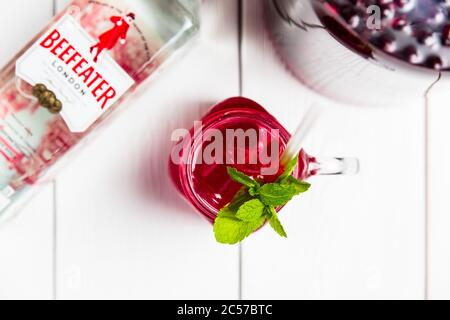 Bielorussia, Minsk, 24 maggio 2018. Un fresco cocktail alcolico di ciliegia in un vaso di vetro con Beefeater London Dry Gin, ghiaccio e menta. Foto Stock