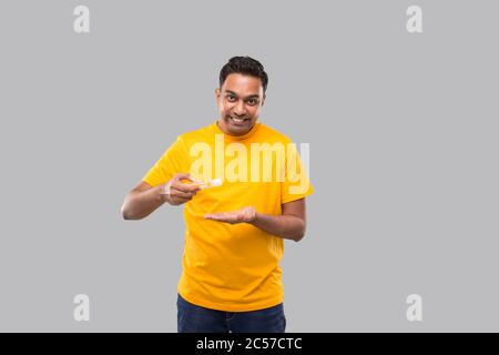 L'uomo indiano che usa l'igienizzatore delle mani isolato. Uomo indiano che usa antisettico mano Foto Stock