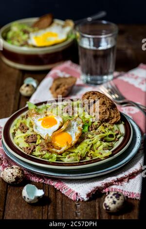 Piatto in padella, cavolo appuntito, manzo tritato, uova fritte da uova di quaglia Foto Stock