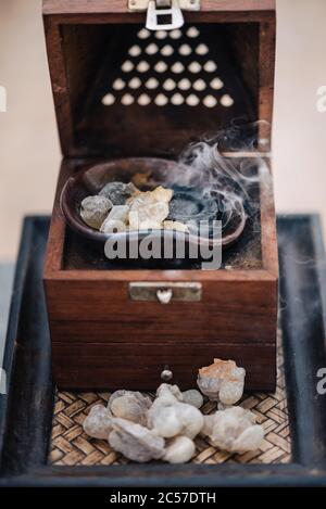 Un tradizionale fornello o bruciatore di frankincenso Omani, utilizzando lacrime di resina sacra di Boswellia, di provenienza locale, riscaldate in modo da emettere i loro aromi unici Foto Stock