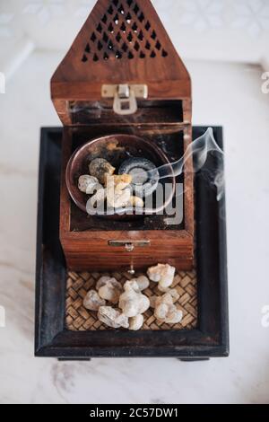 Un tradizionale fornello o bruciatore di frankincenso Omani, utilizzando lacrime di resina sacra di Boswellia, di provenienza locale, riscaldate in modo da emettere i loro aromi unici Foto Stock