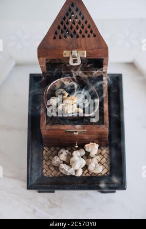 Un tradizionale fornello o bruciatore di frankincenso Omani, utilizzando lacrime di resina sacra di Boswellia, di provenienza locale, riscaldate in modo da emettere i loro aromi unici Foto Stock