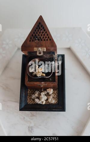 Un tradizionale fornello o bruciatore di frankincenso Omani, utilizzando lacrime di resina sacra di Boswellia, di provenienza locale, riscaldate in modo da emettere i loro aromi unici Foto Stock