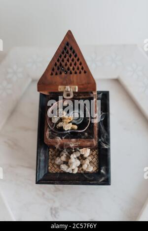 Un tradizionale fornello o bruciatore di frankincenso Omani, utilizzando lacrime di resina sacra di Boswellia, di provenienza locale, riscaldate in modo da emettere i loro aromi unici Foto Stock