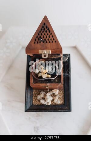 Un tradizionale fornello o bruciatore di frankincenso Omani, utilizzando lacrime di resina sacra di Boswellia, di provenienza locale, riscaldate in modo da emettere i loro aromi unici Foto Stock