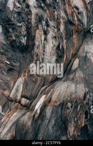 Primo piano di una superficie rocciosa di colore marrone rossastro, nero e bianco Foto Stock