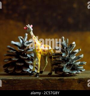 Giraffe figurine e coni di pino natalizio Foto Stock