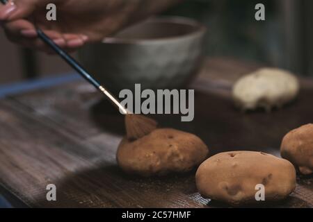 La cottura di torte di patate sul legno scuro dello sfondo. cottura sfera di rum. Foto Stock