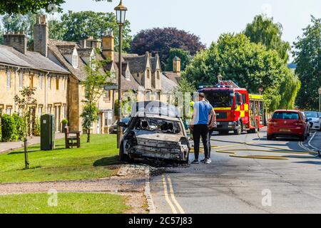 Un'auto completamente bruciata sul lato della strada in High Street, Chipping Campden, una piccola città di mercato nel Cotswolds in Gloucestershire Foto Stock