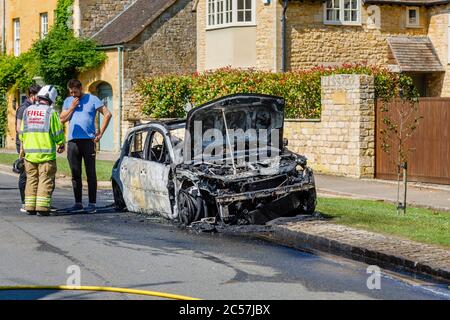 Un'auto completamente bruciata sul lato della strada in High Street, Chipping Campden, una piccola città di mercato nel Cotswolds in Gloucestershire Foto Stock