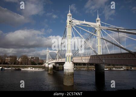 Vista sul Tamigi, sul lato sud di Battersea, guardando verso Chelsea, sul ponte Albert il 1° febbraio 2020 a Londra, Inghilterra, Regno Unito. Albert Bridge è un ponte stradale sulla Tideway del Tamigi che collega Chelsea nel centro di Londra a nord, riva sinistra a Battersea a sud. Progettato e costruito da Rowland Mason Ordish nel 1873. Foto Stock