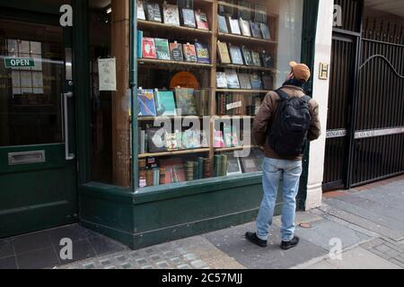 Il 18 febbraio 2020, a Londra, Inghilterra, Regno Unito, si passa la vetrina di libri rari e di seconda mano su Charing Cross Road. Charing Cross Road è rinomata per le sue librerie specializzate e di seconda mano, ed è sede di molte librerie e più negozi di seconda mano e antiquari. Foto Stock