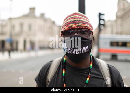 Ritratto di un protester in maschera facciale, dimostrazione Black Lives Matter, Downing Street, Londra, 27 giugno 2020 Foto Stock