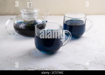 Tè Blue Thai Anchan in due tazze di vetro e una teiera di vetro. Bel colore indaco. Spazio di copia. Foto Stock