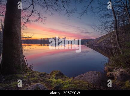 Paesaggio scenico tramonto con lago tranquillo e bei colori alla sera d'estate in Finlandia Foto Stock
