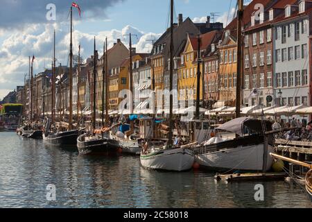 Vista lungo Nyhavn (Nuovo Porto) canal foderato con barche e ex commerciante case Foto Stock