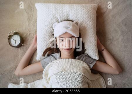 Cute ragazza teen si svegliò in su in mattinata in una maschera di sonno a casa Foto Stock