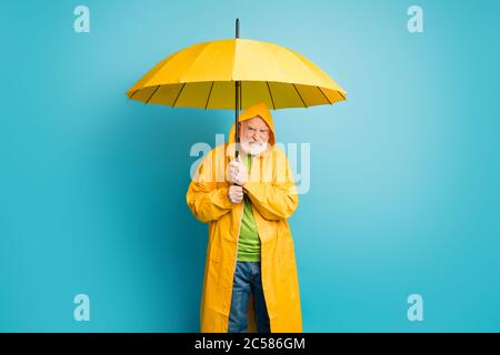 Ritratto del suo insoddisfatto irritato infastidito fungo uomo dai capelli grigi che indossa il soprabito giallo dissimile ciclone maltempo isolato su luminoso Foto Stock