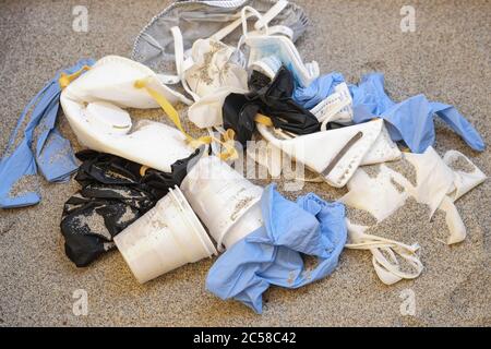 Maschera e guanti di plastica, rifiuti medici monouso sulla costa del mare, inquinamento covide, ecosistema sporco Foto Stock