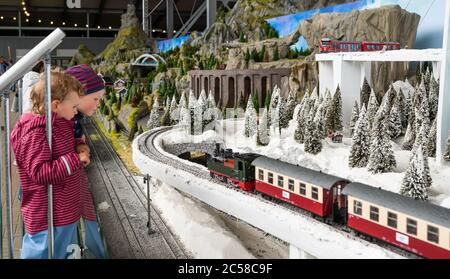 Bispingen, Germania. 01 Luglio 2020. Due bambini guardano un treno di passaggio sulla disposizione della ferrovia del modello. Un totale di 500 treni devono rotolare attraverso vari mondi a tema su un percorso iniziale di 20 chilometri. La struttura, di 12,000 metri quadrati, si trova sotto la parte dello ski hall Snow Dome che sorge su palafitte. Secondo l'operatore, è il più grande modello di impianto ferroviario del mondo. Credit: Philippe Schulze/dpa/Alamy Live News Foto Stock