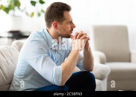 Ragazzo che pensa a casa sul divano Foto Stock