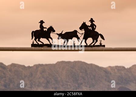 Cartello in ferro battuto al cancello nel deserto di Chihuahuan vicino a Presidio, Texas, USA con massiccio della Sierra Grande attraverso Rio Grande in Messico in distanza Foto Stock