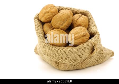 noci fresche in una borsa a scappone su fondo bianco Foto Stock