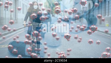 Covid-19 cellule contro donna che indossa maschera facciale bicicletta in strada Foto Stock