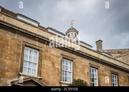 Aspetto verticale di una delle famose vecchie università della Cambridge University. Mostra le finestre a telaio e la torre dell'orologio decorativa. Foto Stock