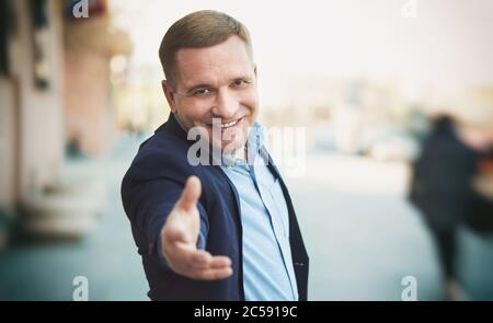 Ritratto di un uomo di mezza età attraente, riuscito e felice. Bel ragazzo sta sorridendo indossando un vestito blu Foto Stock