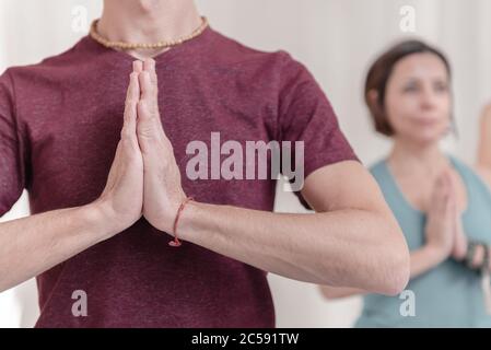 Primo piano delle mani nel gesto di Namaste. L'uomo in primo piano con le mani nel gesto di Namaste. Come tenere le braccia in aria per una K Foto Stock