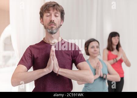 L'uomo in primo piano con le mani nel gesto di Namaste. Primo piano di meditazione dell'uomo presso lo studio di yoga. Come tenere le braccia in aria per un Kriya Foto Stock