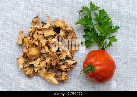 funghi, pomodoro e verdi su un tovagliolo di tela. layout culinario Foto Stock