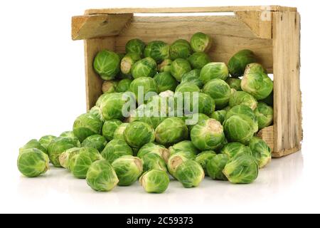 brussel appena raccolto germogli in una cassa di legno su uno sfondo bianco Foto Stock